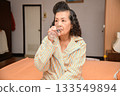 Grandma is taking medicine before going to bed. 133549894