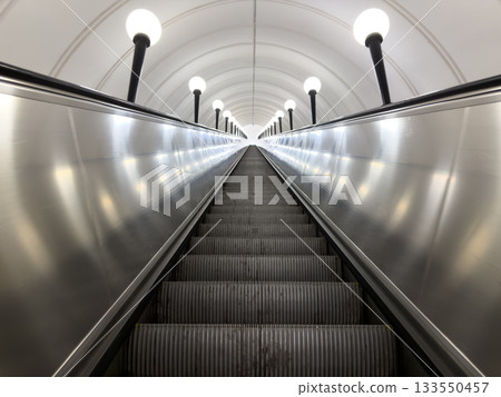 Symmetrical photo of long escalator going up. Concept of personal growth, career development, and successful success in life and work. Escalator leading upward to victory and achievement Symmetrical photo of long escalator going up. Concept of personal growth, career development, and successful success in life and work. Escalator leading upward to victory and achievement 133550457