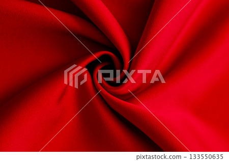 Vibrant red fabric swirl with bold folds and smooth texture for dramatic background 133550635