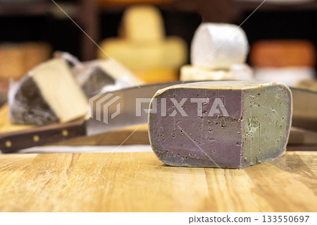 Purple cheese wheel on a wooden counter in a cozy cheese shop Purple cheese wheel on a wooden counter in a cozy cheese shop 133550697
