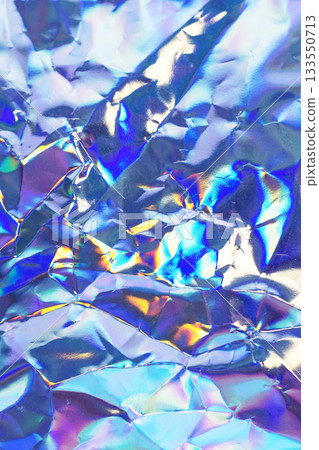 Iridescent crumpled foil texture with metallic surface in rainbow colors Iridescent crumpled foil texture with metallic surface in rainbow colors 133550713