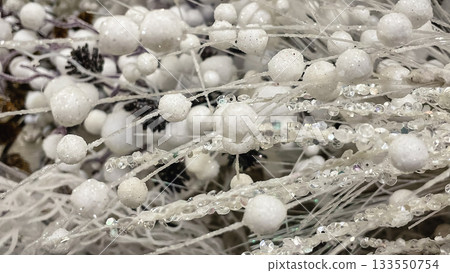 Abstract winter background of white frosted berries and clear sparkling beads on decorative branches Abstract winter background of white frosted berries and clear sparkling beads on decorative branches 133550754
