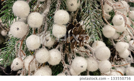 Christmas background with frosted pine needles white glittering berries and a natural pine cone decor Christmas background with frosted pine needles white glittering berries and a natural pine cone decor 133550756
