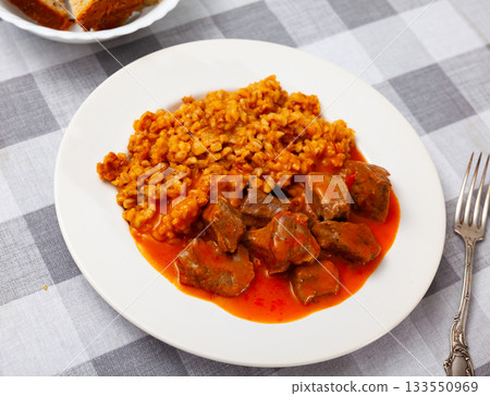 There is portion of hearty food on plate - pearl barley with beef stew in tomato sauce There is portion of hearty food on plate - pearl barley with beef stew in tomato sauce 133550969