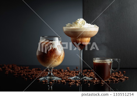 Black coffee and iced coffee cocktails on a black reflective background. Black coffee and iced coffee cocktails on a black reflective background. 133551254