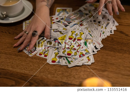 Tarot cards and fortune telling. Soothsayer predicting future with tarot cards. Unrecognizable mysterious fortuneteller holding tarot cards forecasting future for client. Future reading esoteric Tarot cards and fortune telling. Soothsayer predicting future with tarot cards. Unrecognizable mysterious fortuneteller holding tarot cards forecasting future for client. Future reading esoteric 133551416