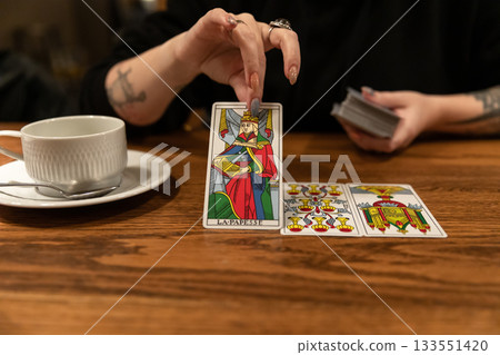 Tarot cards and fortune telling. Soothsayer predicting future with tarot cards. Unrecognizable mysterious fortuneteller holding tarot cards forecasting future for client. Future reading esoteric Tarot cards and fortune telling. Soothsayer predicting future with tarot cards. Unrecognizable mysterious fortuneteller holding tarot cards forecasting future for client. Future reading esoteric 133551420