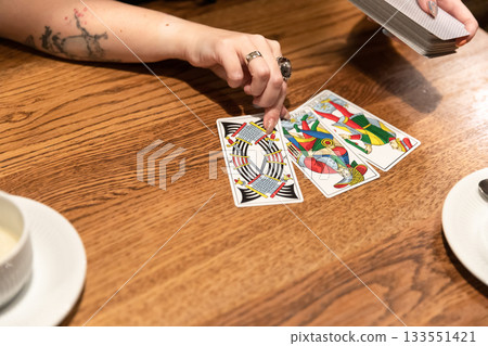 Tarot cards and fortune telling. Soothsayer predicting future with tarot cards. Unrecognizable mysterious fortuneteller holding tarot cards forecasting future for client. Future reading esoteric 133551421