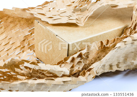 Close up parcel wrapped in eco-friendly wrapping paper, lightweight bubble wrap for protective packaging, friendly Honeycomb paper hexagonal shape made of cardboard recycled paper. 133551436
