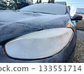 Frozen and white frost covered headlight of a dark car 133551714