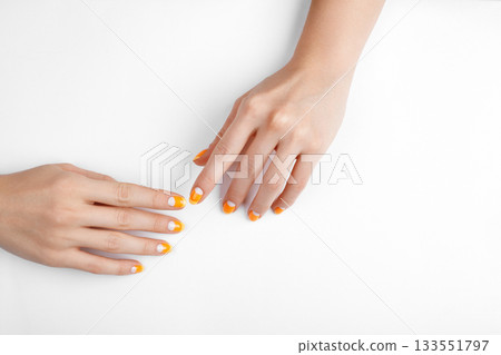 Beautiful Female Hands with bright orange Manicure like Candy Corn. Manicured Nails with Yellow Gel Polish. Halloween Style 133551797