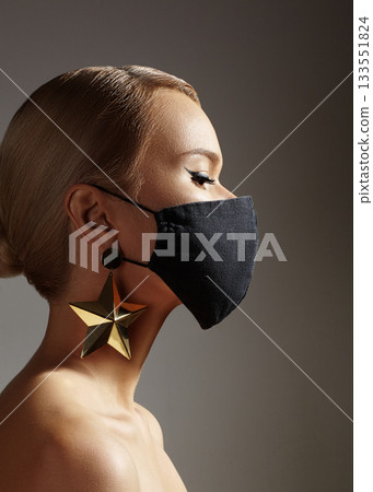 Beautiful Woman with Black Medical Mask on Face. Festive Look with Gold Accessory. Protection Covid-19 Pandemic 133551824