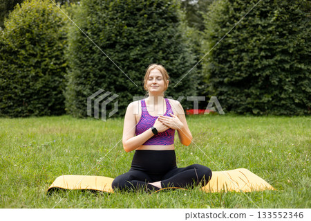 Beautiful pregnant woman doing yoga in the city park. Motherhood and sport banner. High quality photo 133552346
