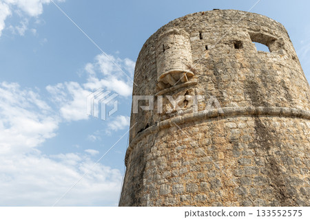 A weathered round tower fortress rises from rugged stone walls. Budwa old town 133552575
