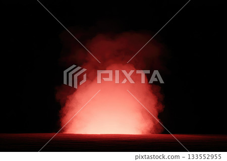 Defocused lava fountain at night with surreal glowing red smoke, dramatic volcanic eruption, intense heat, and mysterious atmosphere in dark landscape 133552955
