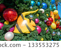 A close-up view of a Christmas tree decorated with tropical fish and colorful shiny ornaments. The bright decorations combine ocean and holiday themes for a fun coastal Christmas design. 133553275
