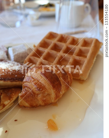 Golden Croissant, Waffle, And Pancake Breakfast Platter For Cozy Morning Brunch Setting 133554180