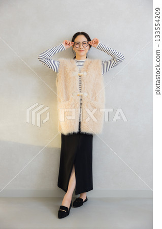 Woman wearing a fur vest 133554209