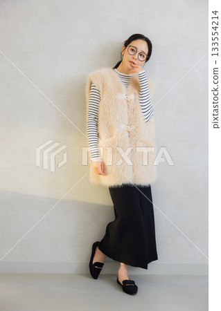 Woman wearing a fur vest 133554214