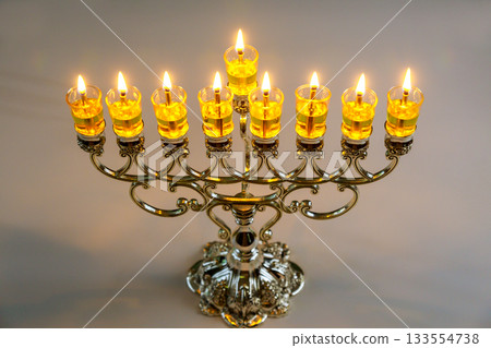 Glowing candles light up beautiful menorah on Jewish holiday its intricate during festive Hanukkah celebration Glowing candles light up beautiful menorah on Jewish holiday its intricate during festive Hanukkah celebration 133554738