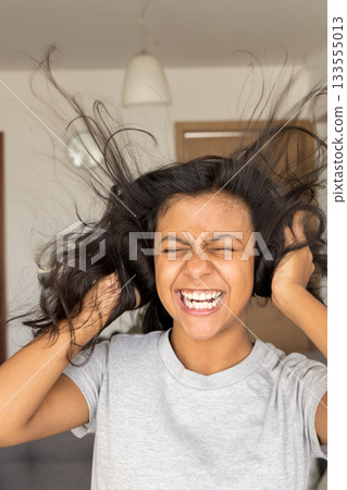 Cute teenager listening to music with her earphones Cute teenager listening to music with her earphones 133555013