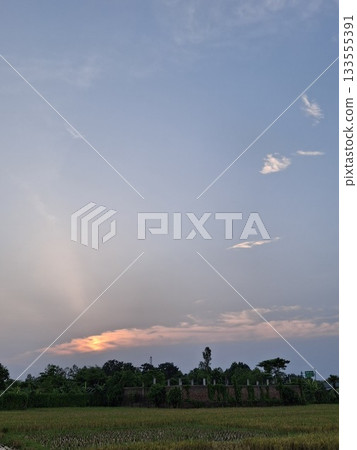 Serene sunset over a distant church and rural landscape Serene sunset over a distant church and rural landscape 133555391