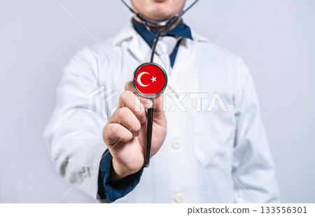 Healthcare worker holding stethoscope with Turkey flag. Turkey health and care concept 133556301