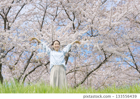 A woman taking a deep breath in front of cherry blossoms A woman taking a deep breath in front of cherry blossoms 133556439