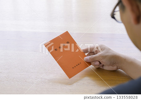 一名男子正在看他的退休金簿 133558028