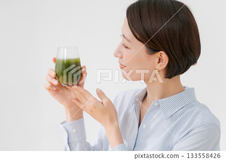 A woman drinking green juice A woman drinking green juice 133558426