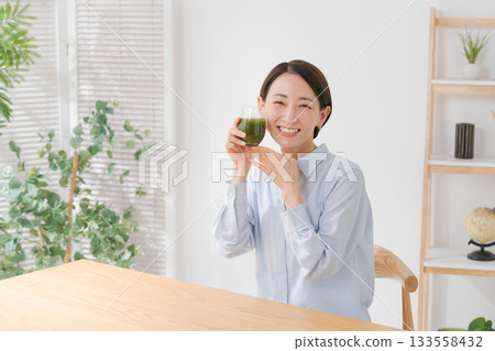 A woman drinking green juice 133558432