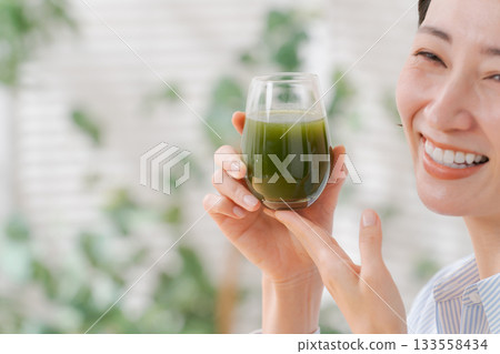喝綠色汁液的婦女 喝綠色汁液的婦女 133558434