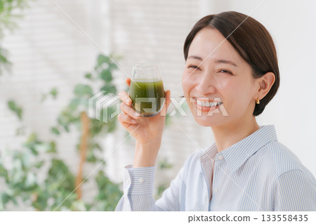 喝綠色汁液的婦女 133558435
