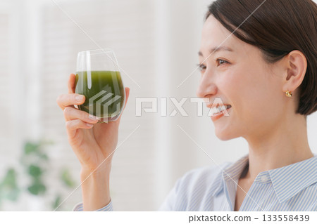 A woman drinking green juice 133558439