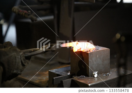 將加熱的材料錘打成形狀的工匠 將加熱的材料錘打成形狀的工匠 133558478
