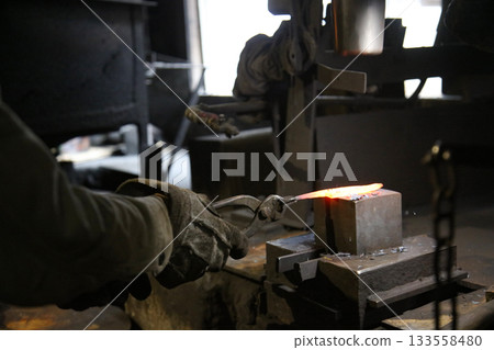 將加熱的材料錘打成形狀的工匠 133558480
