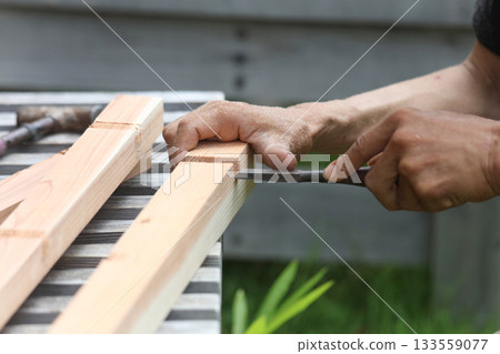 A man cutting wood with a chisel A man cutting wood with a chisel 133559077