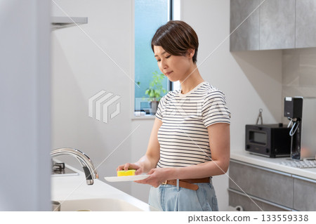 A woman washing dishes in the kitchen (housework, housewife) 133559338