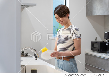 一位婦女在廚房洗碗（家務，家庭主婦） 133559340