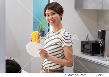 Woman washing dishes in the kitchen (housework / housewife) 133559438