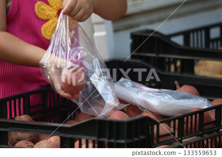 把馬鈴薯放進袋子裡的女孩 把馬鈴薯放進袋子裡的女孩 133559653