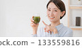 一名女子正在喝綠色果汁（橫幅） 133559816
