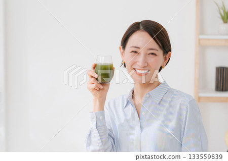 A woman drinking green juice 133559839
