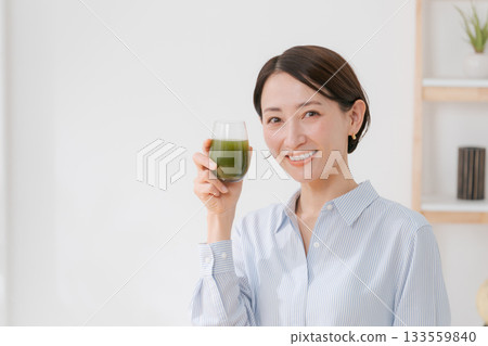 A woman drinking green juice 133559840