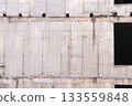 Concrete Wall Frame of Building under Construction with Formwork Prints Smudges on Surface. Architectural origin of Structure. Monolithic box with holes window and formwork beams at Construction Site. 133559848