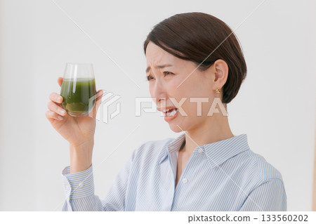 一名女子正在喝苦綠果汁 133560202