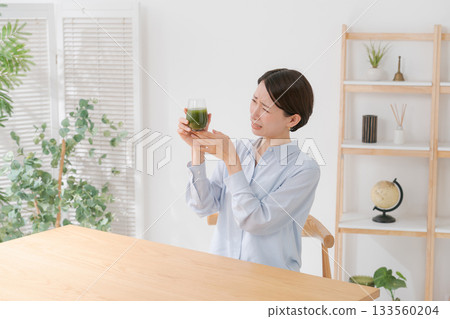 一名女子正在喝苦綠果汁 一名女子正在喝苦綠果汁 133560204