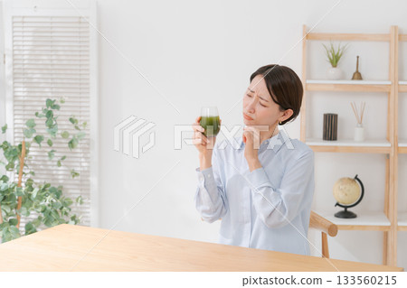 一名女子正在喝苦綠果汁 一名女子正在喝苦綠果汁 133560215