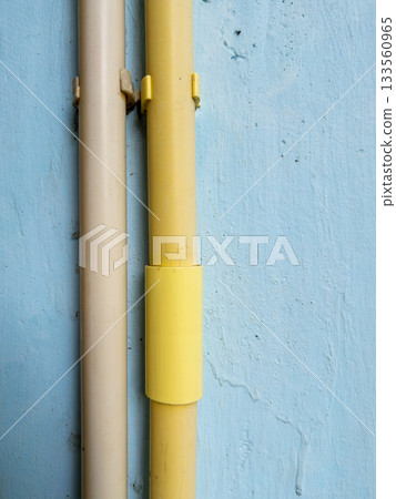 PVC electrical conduit pipes attached on house wall for wiring installation. 133560965
