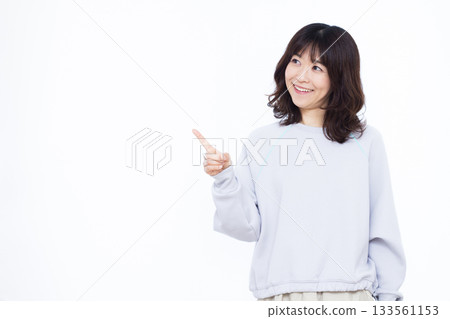 Smiling woman pointing up her index finger 133561153
